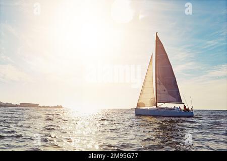 Mockup, coucher de soleil et un yacht en mer pour le voyage, le tourisme ou des vacances d'été de luxe en plein air. Ciel bleu, eau et vague avec un bateau sur l'océan dans la nature Banque D'Images