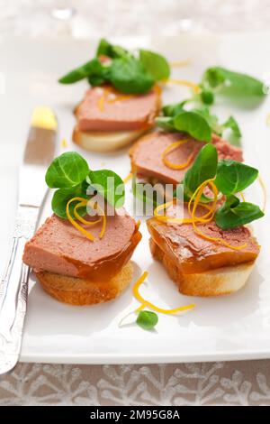 Délicieux hors-d'œuvre de Pâques pour le dîner de vacances. Pâté de foie de poulet avec gelée d'orange et salade de maïs frais sur un plat blanc. Banque D'Images