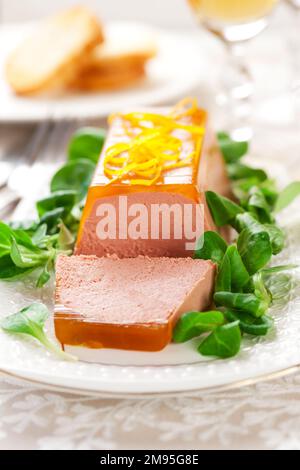 Délicieux hors-d'œuvre de Pâques pour le dîner de vacances. Pâté de foie de poulet avec gelée d'orange et salade de maïs frais sur un plat blanc. Banque D'Images