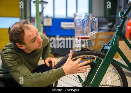 17 janvier 2023, Saxe-Anhalt, Magdebourg: Marcus Schlüter, professeur étudiant de technologie et d'études sociales à l'Université Otto von Guericke de Magdeburg, teste un mélangeur monté sur un vélo dans l'atelier prototype IP-Logmo - prototypes intelligents pour la logistique et la mobilité à l'Université Otto von Guericke de Magdeburg. Le vélo smoothie y a été construit par des professeurs étudiants du thème d'enseignement technologie de la Chaire d'enseignement de l'ingénierie et de la didactique de l'éducation technique et mélangent des smoothies pour les visiteurs à la semaine verte internationale 2023. Le vélo Smoothie fonctionne sans électricité Banque D'Images