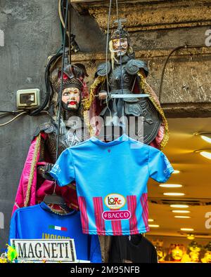 Les marionnettes siciliennes, les marionnettes siciliennes traditionnelles exposées à la vente, et les chemises de joueurs célèbres offertes comme souvenirs. Catane, Sicile Banque D'Images