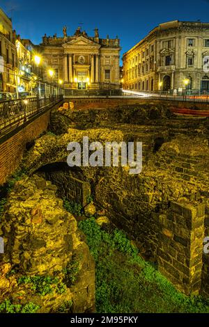 Ruines au-dessous du niveau de la rue d'un grand amphithéâtre romain de 300 av. J.-C. Dans le centre de Catane à la lumière du crépuscule. Catane, Sicile, Italie, Europe Banque D'Images