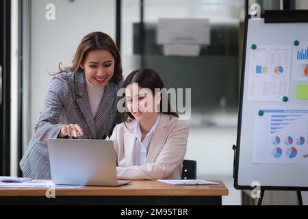 Graphique d'analyse du travail d'équipe en salle de réunion. Réunion des conseillers d'affaires asiatiques pour analyser le rapport financier et en discuter Banque D'Images