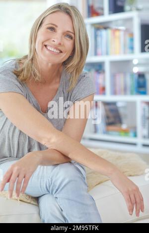 Femme, portrait heureux et se détendre sur le canapé à la maison pour la pleine conscience du bonheur, l'état d'esprit positif et l'énergie calme. Femme, sourire et calme relaxant, pensif Banque D'Images