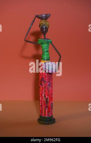 Figure décorative en papier sous forme de femme noire avec plaque. Fille noire en vêtements nationaux avec bol sur la tête Banque D'Images