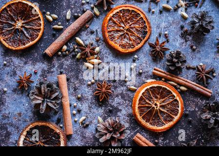 Encore plus de vie avec set de vin chaud. Orange séché, bâtonnets de cannelle, poivre rose, cardamome, anis, fond bleu closes. vue du dessus Banque D'Images