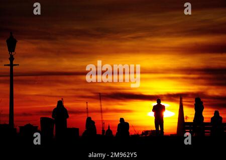Les gens regardent le soleil se lever de Primrose Hill dans l'ouest de Londres pendant une matinée froide et glaciale. Date de la photo: Mardi 17 janvier 2023. Banque D'Images