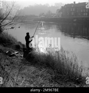 Un pêcheur à la ligne jette sa ligne dans la rivière Severn dans la lumière brumeuse du matin à Bewdley, Worcestershire. Photographie de Norman Synge Waller Budd Banque D'Images