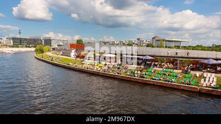 Berlin, Allemagne - 6 juillet 2011 : foules assises sur des chaises pliantes sur la rive herbeuse de la rivière Spree, jouissant de la vue de Berlin Hauptbahnhof et des s Banque D'Images