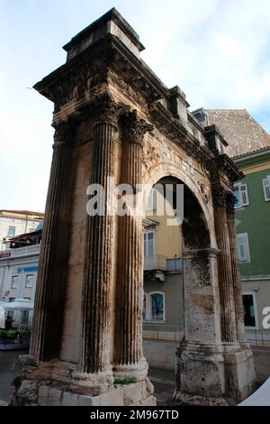 Vue latérale de l'arche triomphale du Sergii à Pula, sur la côte ouest de l'Istrie, Croatie. Cette ancienne arche romaine commémore trois frères de la famille Sergii, en particulier Lucius Sergius Lepidus, une tribune qui a combattu dans la bataille d'Actium. Il a été payé par la femme de Lepidus, Salvia Postuma Sergia, et a été utilisé à l'origine comme porte de ville. Banque D'Images