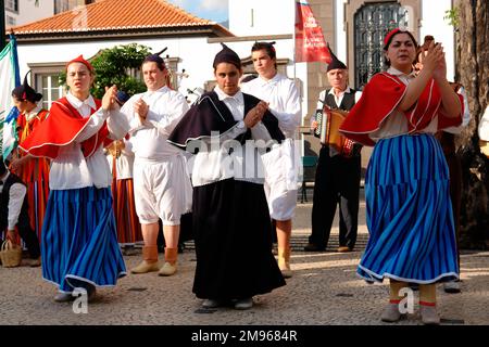 Un groupe folklorique du village de Camacha, dansant dans la rue de Funchal, la capitale de Madère. Banque D'Images