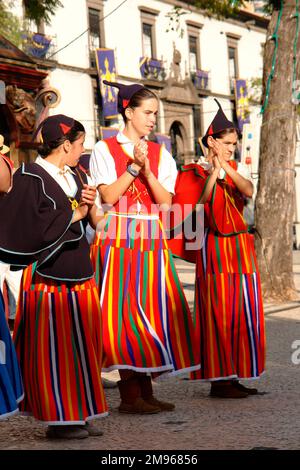 Trois filles d'un groupe folklorique du village de Camacha, vu ici à Funchal, la capitale de Madère. Ils semblent s'accroter à la musique à temps. Banque D'Images