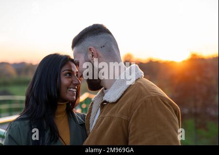 Couple heureux en amour dehors tandis que le soleil brille au coucher du soleil, amour et Saint Valentin concept de jour Banque D'Images