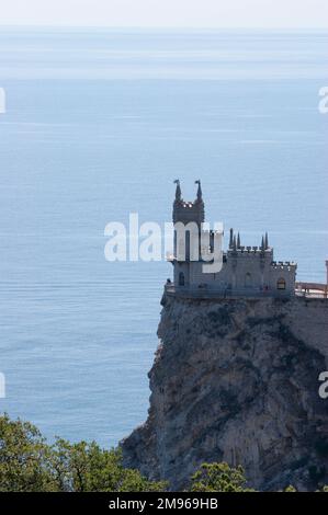 Vue sur un château néo-gothique connu sous le nom de Nest de Swallow, au bord d'une falaise au-dessus de la mer Noire, près de Yalta, Ukraine. Construit par un noble allemand en 1912, il abrite aujourd'hui un restaurant italien. Banque D'Images