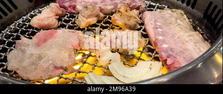 Griller de la viande de porc sur un filet barbecue en fer rond dans le restaurant pour manger, frais délicieux cuisine mode de vie. Banque D'Images