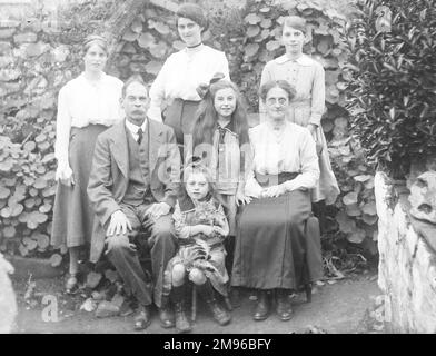 Une famille édouardienne de classe moyenne pose pour une photo de groupe dans un jardin, probablement dans la région du Mid Wales. La petite fille au milieu tient un chat tabby dans ses bras. Banque D'Images