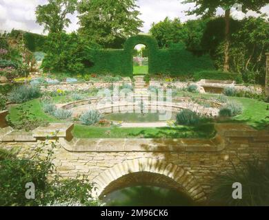 Une fontaine au milieu d'une piscine ornementale, dans un jardin à Broad Campden, près de Chipping Campden, Gloucestershire. Banque D'Images