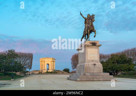 Vue pittoresque sur le paysage de l'aube d'hiver de la statue équestre du roi Louis XIV et de l'ancienne tour d'eau dans le jardin de la Promenade du Peyrou, Montpellier, France Banque D'Images