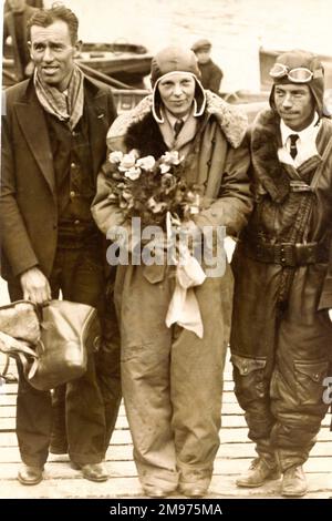 Amelia Earhart, centre; Wilmer Stutz, pilote, à droite; Et Louis Gordon, copilote. Port de Burry, pays de Galles, après leur vol non-stop de Terre-Neuve à partir du 17 juin 1928. Banque D'Images