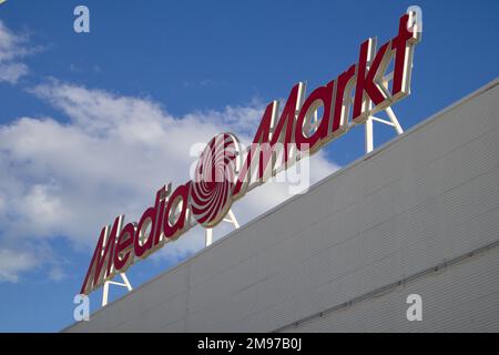 2022. Valence, Espagne. Logo avec lettres rouges de la marque Media Markt sur l'un de ses magasins de Valence (Espagne) avec ciel bleu et nuages derrière Banque D'Images
