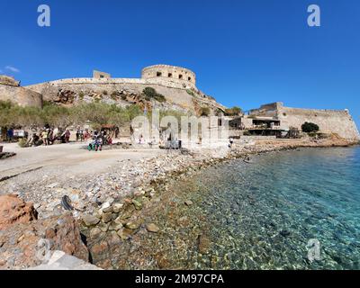 Spinalonga, Crète, Grèce - 10 octobre 2022: Foule de touristes sur la plage avec des bâtiments construits en pierre dans l'ancienne forteresse vénitienne Spinalonga, jusqu'en 1957 Banque D'Images