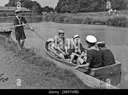 Des scouts de mer dans un bateau à rames sur une rivière. Banque D'Images