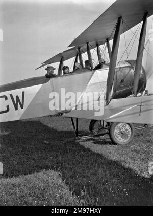 Trois personnes dans un biplan sur un aérodrome. Banque D'Images