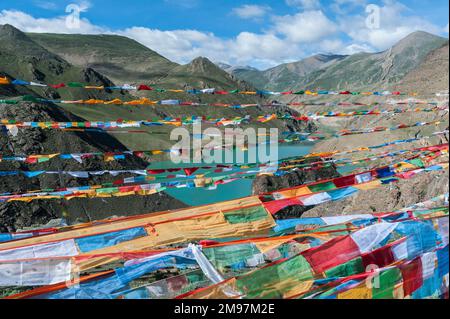 Drapeaux de prière tibétains dans le lac hydroélectrique Yamdrok-tso à SIM ou Simu la Pass, le long de la Southern Friendship Highway, Tibet. Banque D'Images