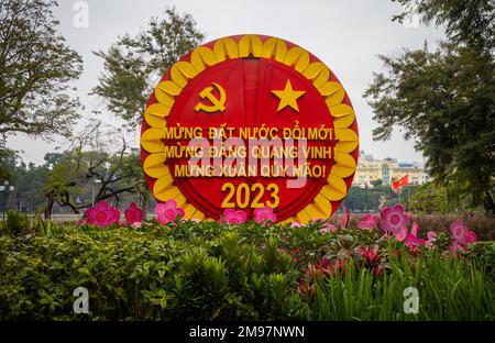 Hanoï, Vietnam, 17 janvier 2023. Un parti communiste propoganda exposition entourée de fleurs pour célébrer la prochaine année lunaire sur l'exposition à côté du lac Hoan Kiem dans le centre de Hanoi, Vietnam. Traduction: 'Happy renouveau Country, Happy Glorious Party (communiste), Happy New Year of the Cat 2023' Banque D'Images