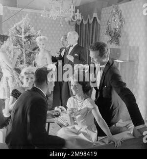 Publicité pour EMU sherry -- modèles masculins et féminins posant dans la scène de fête de Noël. Banque D'Images