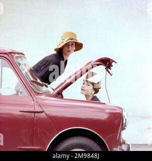 Tatler Cover photoshoot se concentrant sur les chapeaux et le Motor Show -- deux modèles féminins posant avec une mini voiture rouge. Une variante de ce photoshoot particulier a été utilisée pour la couverture du numéro de Tatler du 21 octobre 1959 (voir image 11064837). Banque D'Images