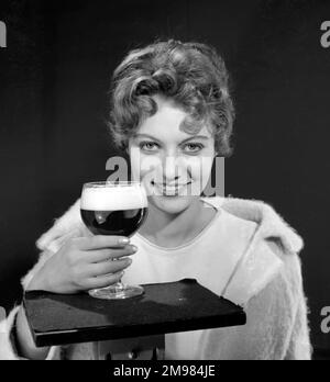 Modèle féminin (Gillian Watt) tenant un verre de bière. Banque D'Images