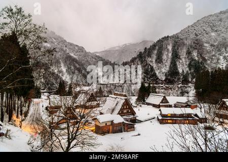 Lumières allumées dans un village enneigé classé au patrimoine mondial de l'UNESCO dans le paysage de montagne à l'aube Banque D'Images