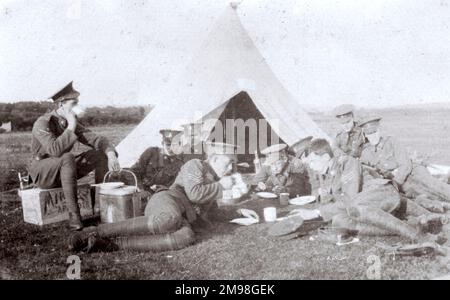 Tente de garde au camp OTC de Petersfield (pour les cadets de l'école St Paul), montrant des hommes en uniforme se détendant sur l'herbe, buvant du thé. Banque D'Images