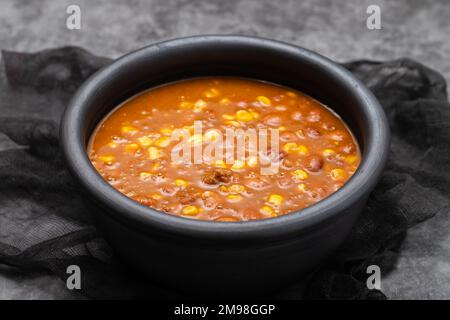 Plat mexicain typique Chili con Carne sur un plat noir Banque D'Images