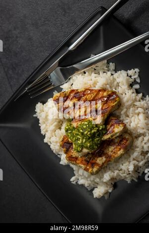 viande de volaille grillée au pesto servie avec du riz Banque D'Images