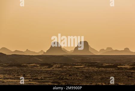 Vue en soirée sur les silhouettes des formations rocheuses dans le désert occidental, en Égypte Banque D'Images