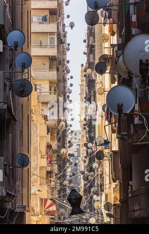 Ruelle étroite avec des plats satellites à Alexandrie, Egypte Banque D'Images