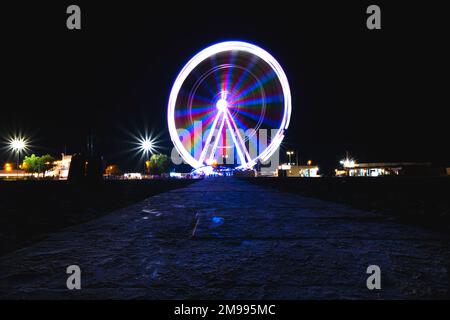 RIMINI, ITALIE - 25 août 2020: Photographie de nuit. Longue exposition de la roue de ferris tournante la nuit sur la côte italienne de la ville de Rimini Banque D'Images