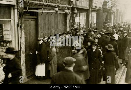 Une file d'attente de nourriture devant un boucher à Londres pendant une pénurie vers la fin de la première Guerre mondiale. Banque D'Images