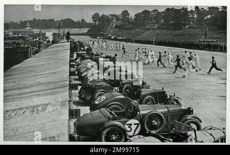 Début d'une course Brooklands Double-Twelve avec des pilotes et des mécaniciens qui s'exécutent sur leurs machines. Banque D'Images