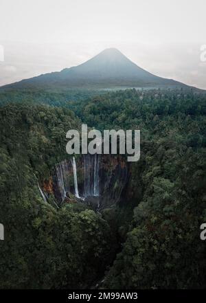 Vue d'en haut, vue aérienne stupéfiante des chutes d'eau de Tumpak Sewu, également connues sous le nom de Coban Sewu, avec des nuages qui s'élèvent du canyon. Banque D'Images
