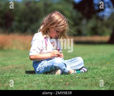 Jeune enfant faisant la guirlande dans le champ, Winkfield, Berkshire, Angleterre, Royaume-Uni Banque D'Images