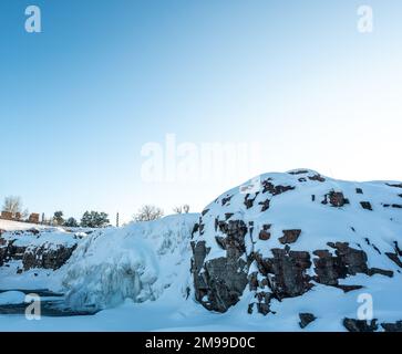 Sioux Falls Park en hiver avec chute d'eau gelée et couverture de neige. Banque D'Images