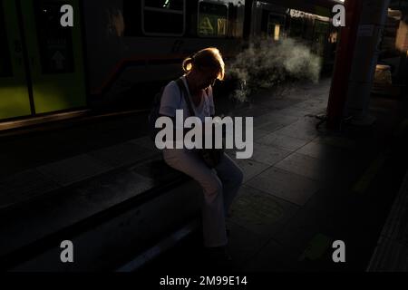 Silhouette femme fumant une cigarette attendant à la gare de Paltform, à Venise Banque D'Images