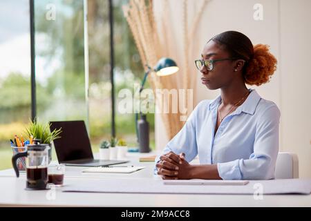Portrait d'une femme d'affaires inquiète travaillant à domicile assis au bureau Banque D'Images
