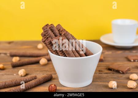 Délicieux petits gâteaux roulés de cachets aux noisettes et morceaux de chocolat sur une table en bois Banque D'Images