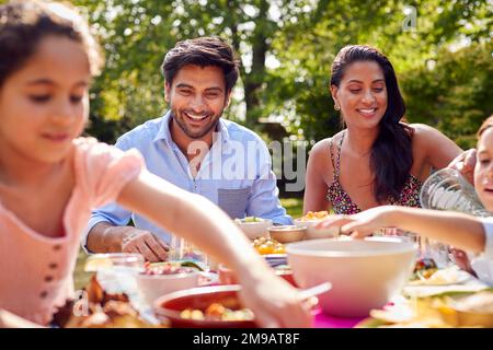 Repas familial en plein air dans le jardin à la maison ensemble Banque D'Images