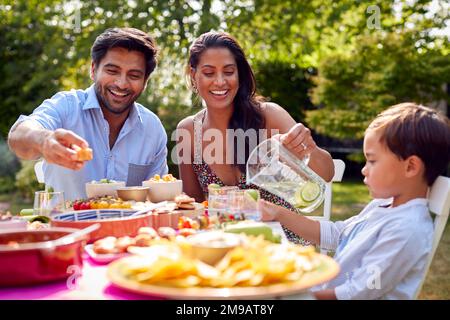 Repas familial en plein air dans le jardin à la maison ensemble Banque D'Images