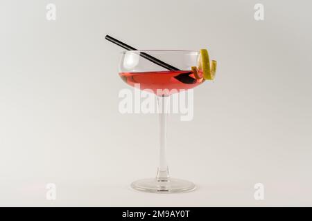 Coupe de champagne avec cocktail de dame rose, touche citron et paille noire isolée sur fond blanc Banque D'Images